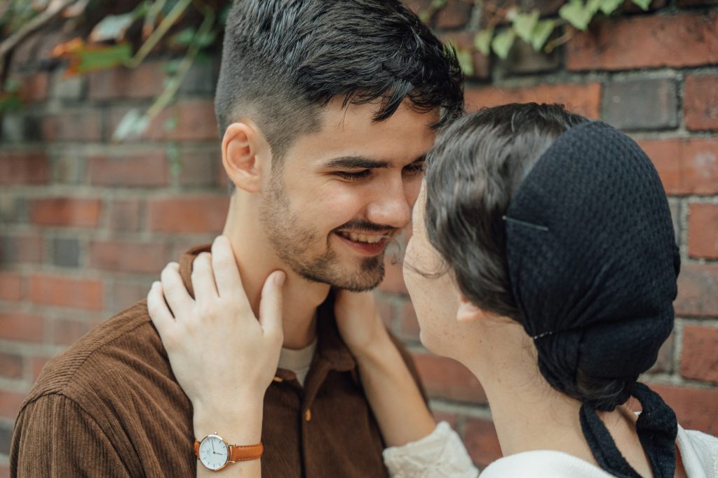 A close-up of Trennis and Maria beside a brick wall