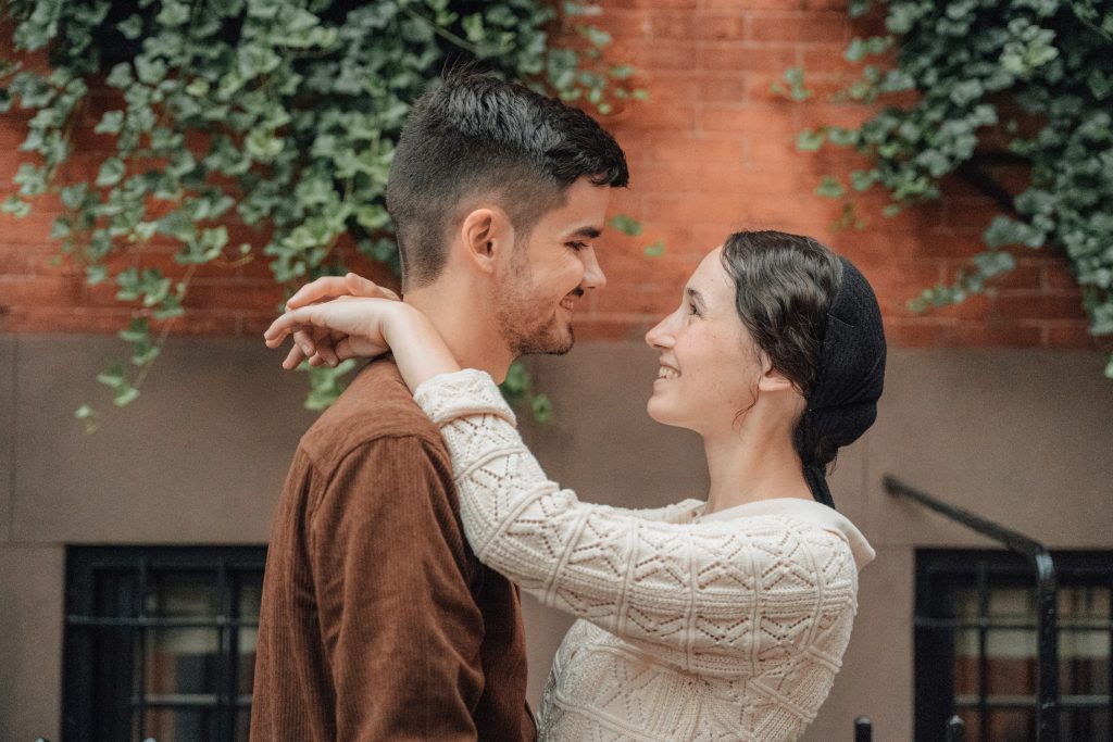 Maria with her arms around Trennis beside a brick building